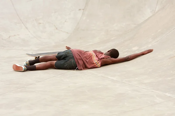 Tonåring lägger på betong efter torka under skateboard kör — Stockfoto