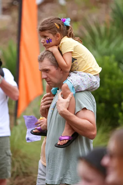 Папа носит дочь на плечах на летнем фестивале бабочек — стоковое фото