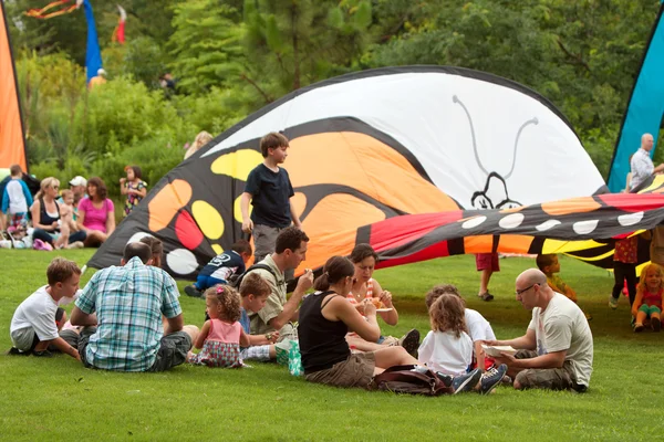 Сім'ї насолоджуватися обід-пікнік на фестивалі літом метелики — стокове фото