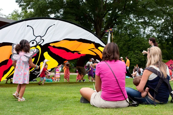 Mödrar se sina barn spelar på butterfly festival — Stockfoto