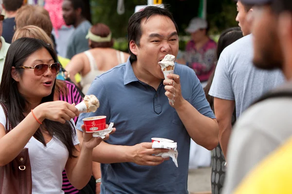 Jeune couple lutte pour manger la fonte des cônes de crème glacée — Photo