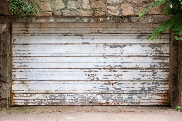 Puerta de garaje vintage cubierta con óxido y pintura astillada Imagen de archivo