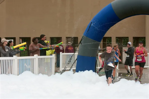 Runners Run Through Squirt Guns and Foam At 5K Race — Stock Photo, Image