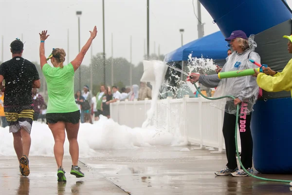 Lopers krijgen gedrenkt door squirt kanonnen bij race finish — Stockfoto