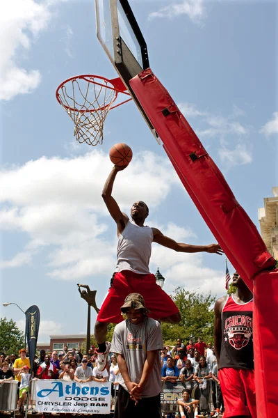 Ung man hoppar över person försöker jam i dunk tävling — Stockfoto