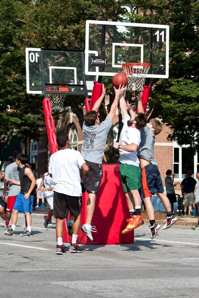 Män hoppa samtidigt kämpar för bollen i street basketturnering — Stockfoto