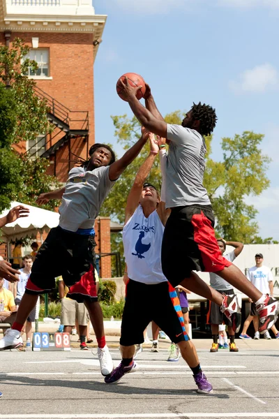 Tre män slåss för rebound i utomhus street basketturnering — Stockfoto