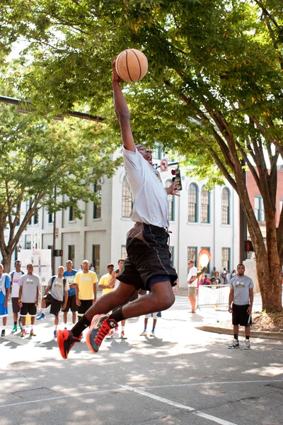 Jeune homme saute à Dunk Basketball pendant le tournoi de rue en plein air — Photo