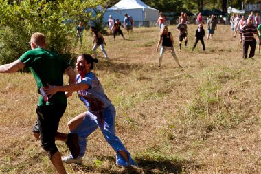 Female Zombie Nurse Chases Runner in Scary 5K Obstacle Race clipart