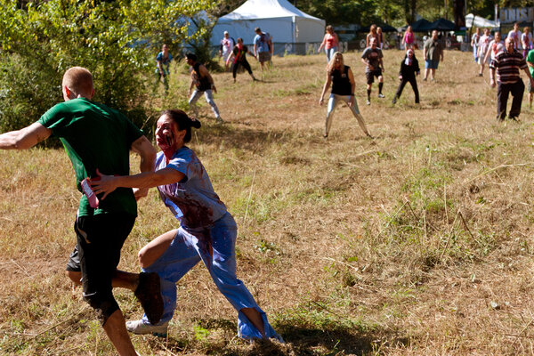 Female Zombie Nurse Chases Runner in Scary 5K Obstacle Race