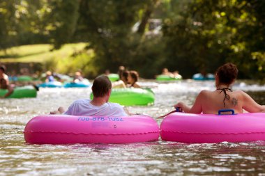 Couple Enjoys Tubing Down River In Summer Heat clipart