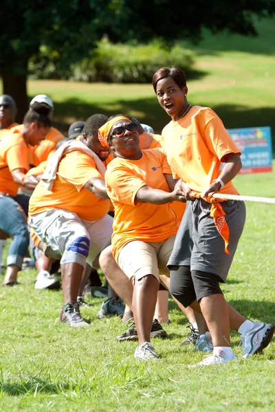 Människor dra rep i team tug-of-war konkurrens — Stockfoto