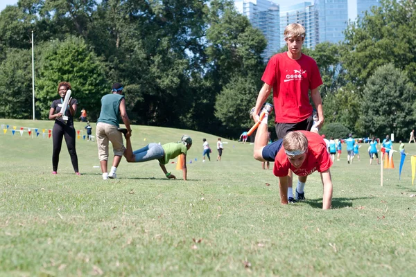 Two Young Men Compete In Wheelbarrow Race At Summer Fundraiser — Stock Photo, Image