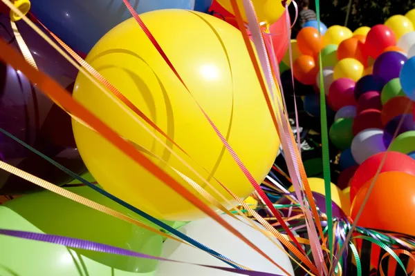 Globos coloridos y cintas en el marco de relleno soleado del festival al aire libre —  Fotos de Stock