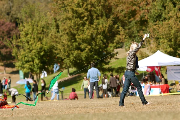 Νεαρή γυναίκα προσπαθεί να εξυπηρετήσουν kite σε δημόσια φεστιβάλ — Φωτογραφία Αρχείου