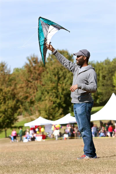 Człowiek posiada kite wysoki aby go powietrzu festiwalu — Stok fotoğraf