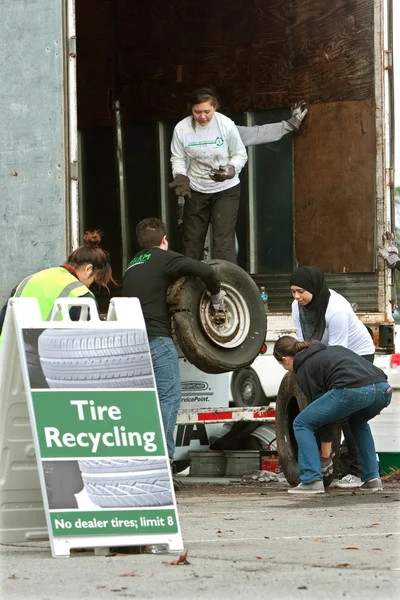 Tiener vrijwilligers verzamelen versleten banden op recycling evenement — Stockfoto