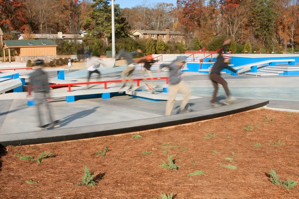 Bewegingsonscherpte composiet van skateboarders genieten van nieuwe skateboard park — Stockfoto