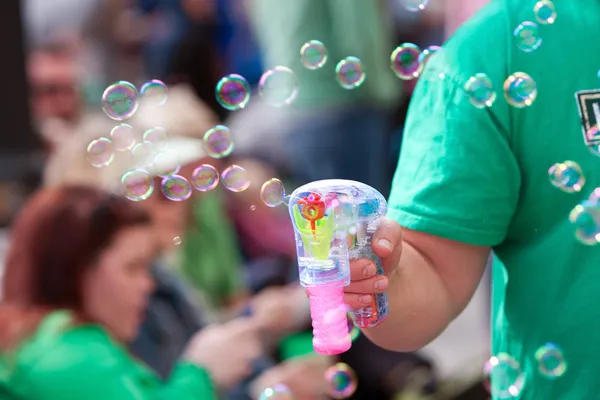 Man Makes Bubbles With Bubble Pistol At Parade — Stock Photo, Image