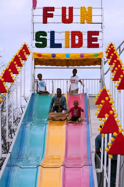 Familie fährt lustige Rutsche auf dem Jahrmarkt — Stockfoto