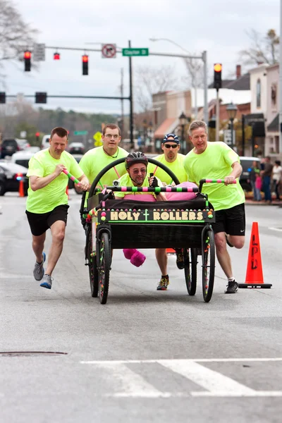 Clergymen spingere Santo Rollers letto in annuale Fundraiser Race — Foto Stock