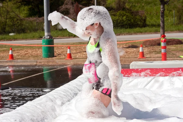 Mulher coberta de espuma em corrida curso de obstáculo louco — Fotografia de Stock