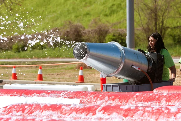 Женщина распыляет пенные пузыри на скачках с сумасшедшими препятствиями — стоковое фото