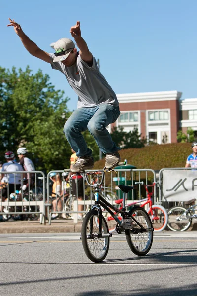 Junger Mann steht am Fahrradlenker und übt für BMX-Wettbewerb — Stockfoto