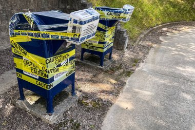 LAWRENCEVILLE, GA - JULY 8, 2022:  Outdoor mail drop boxes at a post office are taped shut with yellow caution tape and temporatily closed on July 8, 2022 in Lawrenceville, GA.