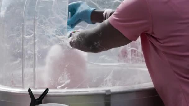 秋祭りで女の手が綿菓子機の棒をひねるのを閉じる — ストック動画
