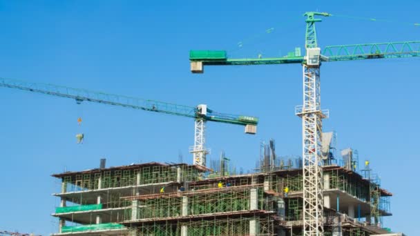 Time lapse crane working in big construction site (zoom out) — Stock Video