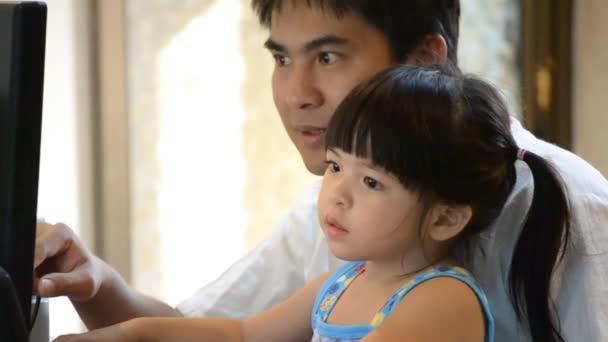 Азиатский отец учил милую дочь играть на компьютере — стоковое видео
