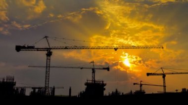 büyük inşaat alanı içinde çalışan zaman sukut günbatımı ve siluet vinç