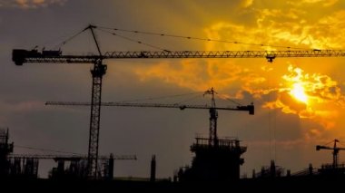 büyük inşaat alanı (uzaklaştırmak çalışan zaman sukut günbatımı ve siluet vinç)