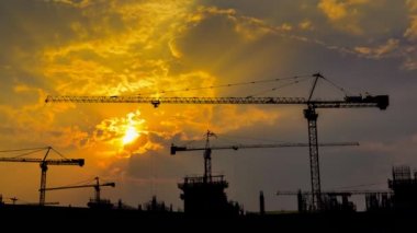 büyük inşaat alanı (yakınlaştırma çalışan zaman sukut günbatımı ve siluet vinç)
