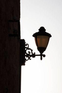 Duvarda eski bir fener asılı..