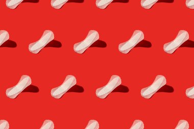 Kırmızı arka planda beyaz adet pedleri. Kusursuz tekrarlama deseni.