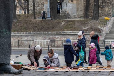 Lviv, Ukrayna - 8 Mart 2022. Ukrayna 'daki savaş. Kadınlar ve çocuklar kitap pazarından kitap satın alırlar..