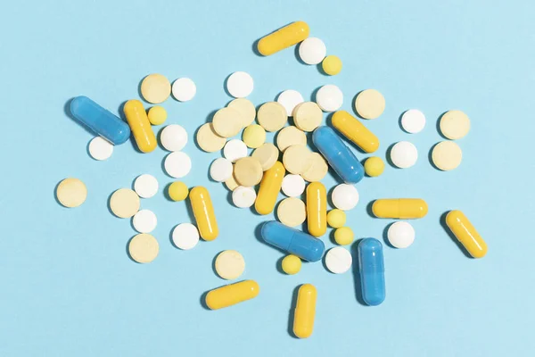 Διαφορετικά Χρωματιστά Χάπια Και Κάψουλες Διάσπαρτα Ένα Μπλε Φόντο — Φωτογραφία Αρχείου