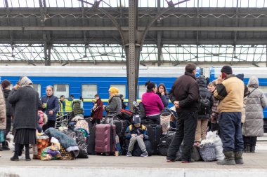 Lviv, Ukraine - March 26, 2022. Crowd of people waiting for the train on the platform. Internally displaced persons. clipart