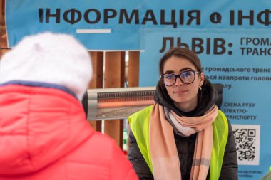 Lviv, Ukraine - March 26, 2022. Volunteer who helps IDPs at the railway station. clipart