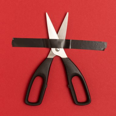 Makas kırmızı arkaplanda siyah yapıştırıcı bantla yapıştırılır..