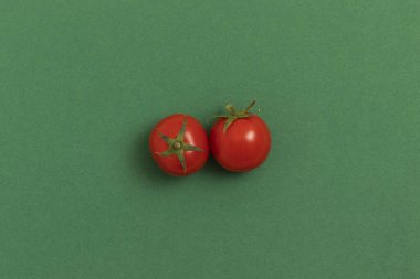 Yeşil arka planda kırmızı kiraz domatesleri. Üst görünüm.