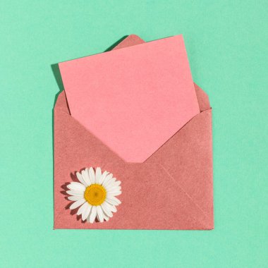 Aquamarine arka planında boş pembe kağıtlı Kraft pembe zarfı.