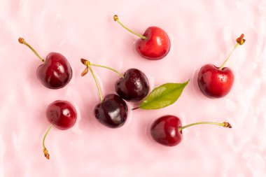 Pembe, durgun sularda tatlı kiraz, sıçramalar ve dalgalarla..