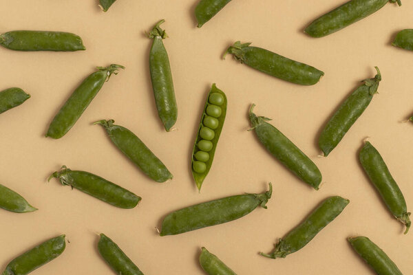 Green peas on a beige background. Top view.