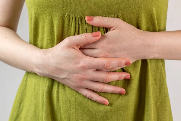 Female hands on stomach. Stomach ache concept.