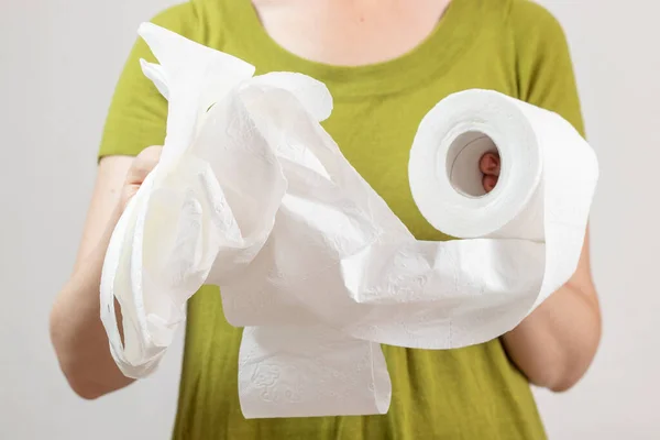 Woman holding a toilet paper in her hand.