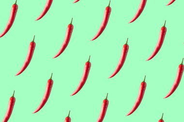 Red hot chili peppers on a green background. Seamless repeating pattern.