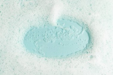 Mavi arka planda beyaz tüylü sabun köpüğü. Üst görünüm.